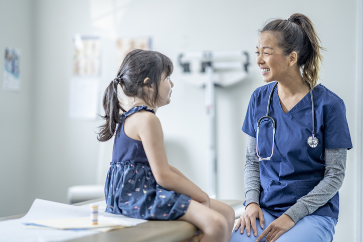 Nurse In scrubs with a child patient