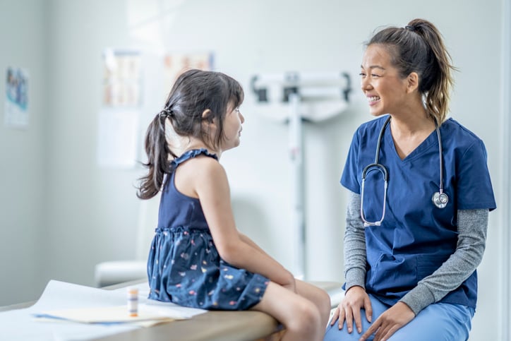 Nurse In scrubs with a child patient Nurse In scrubs with a child patient